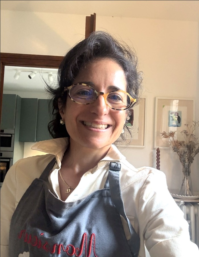 Violeta de Rueda souriante dans sa cuisine, tablier enfilé, prête pour la soirée